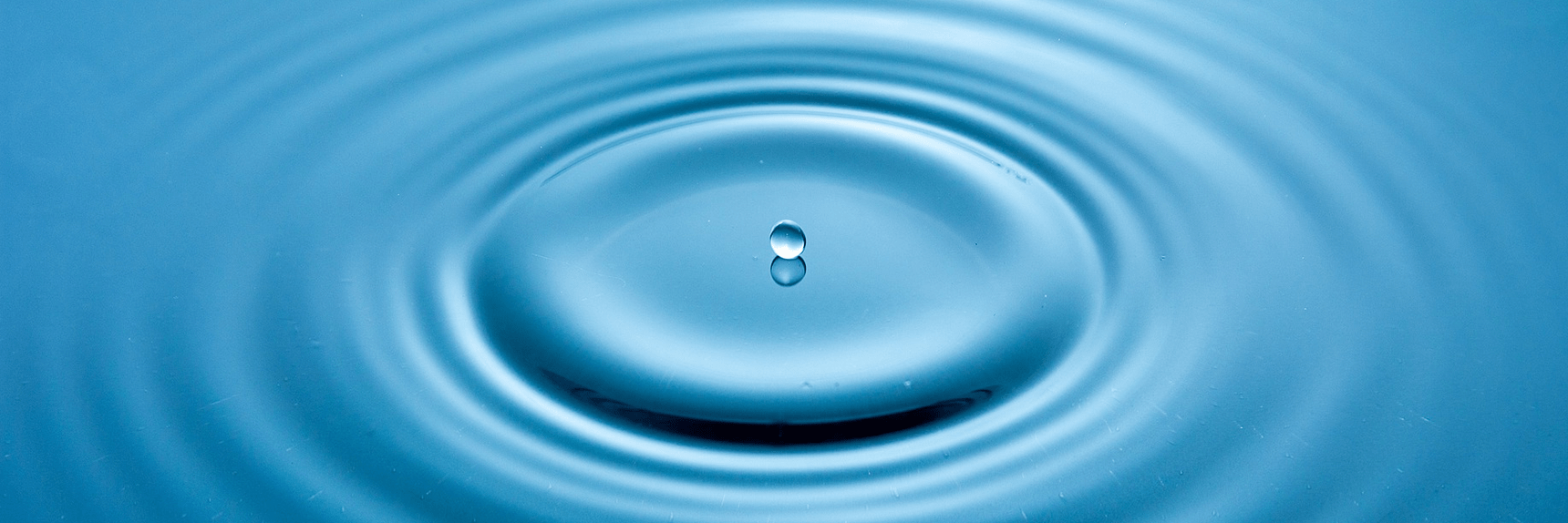 Droplet of water ripples the surface